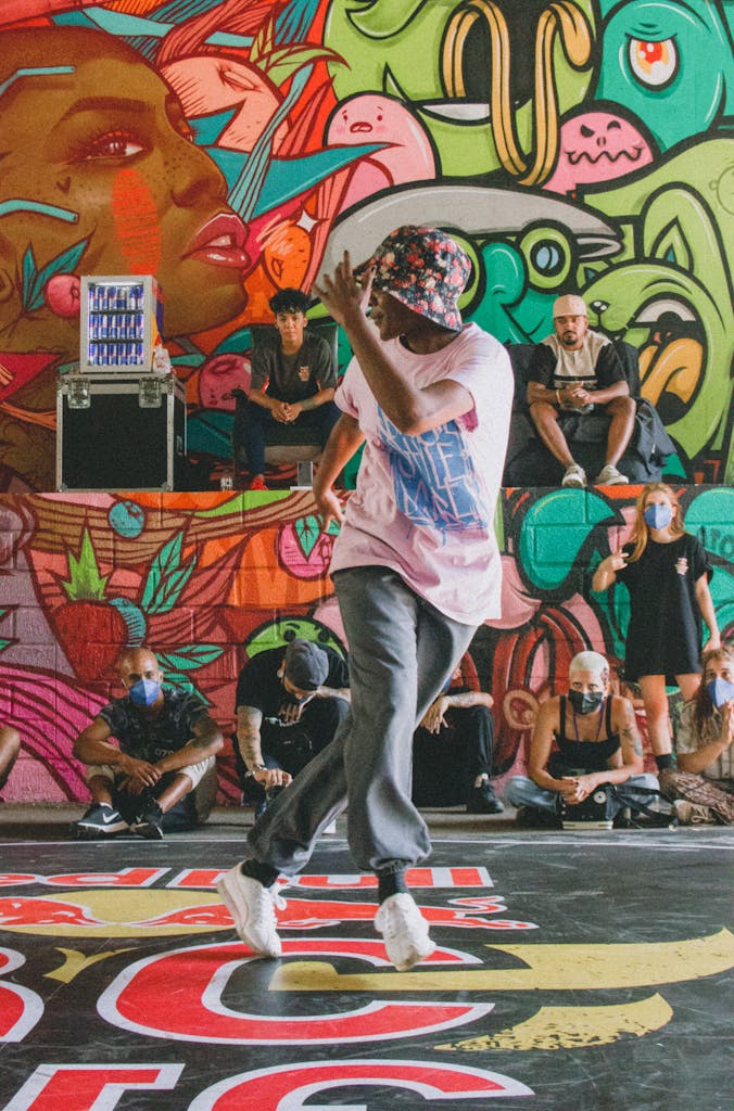Dynamic street dance performance against colorful graffiti backdrop, capturing urban culture and positivity.